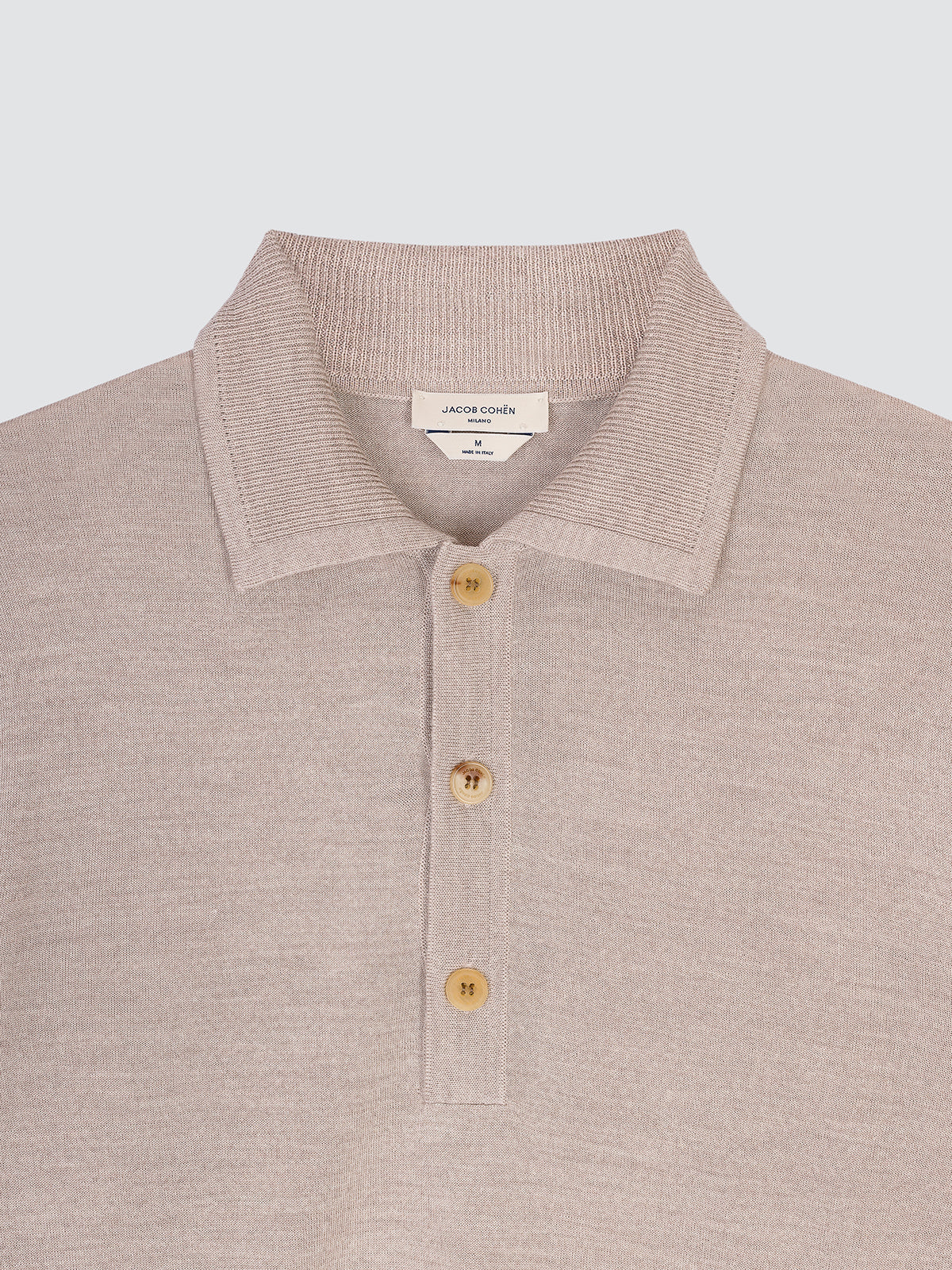 Close-up of the collar and horn buttons of the light greige polo
