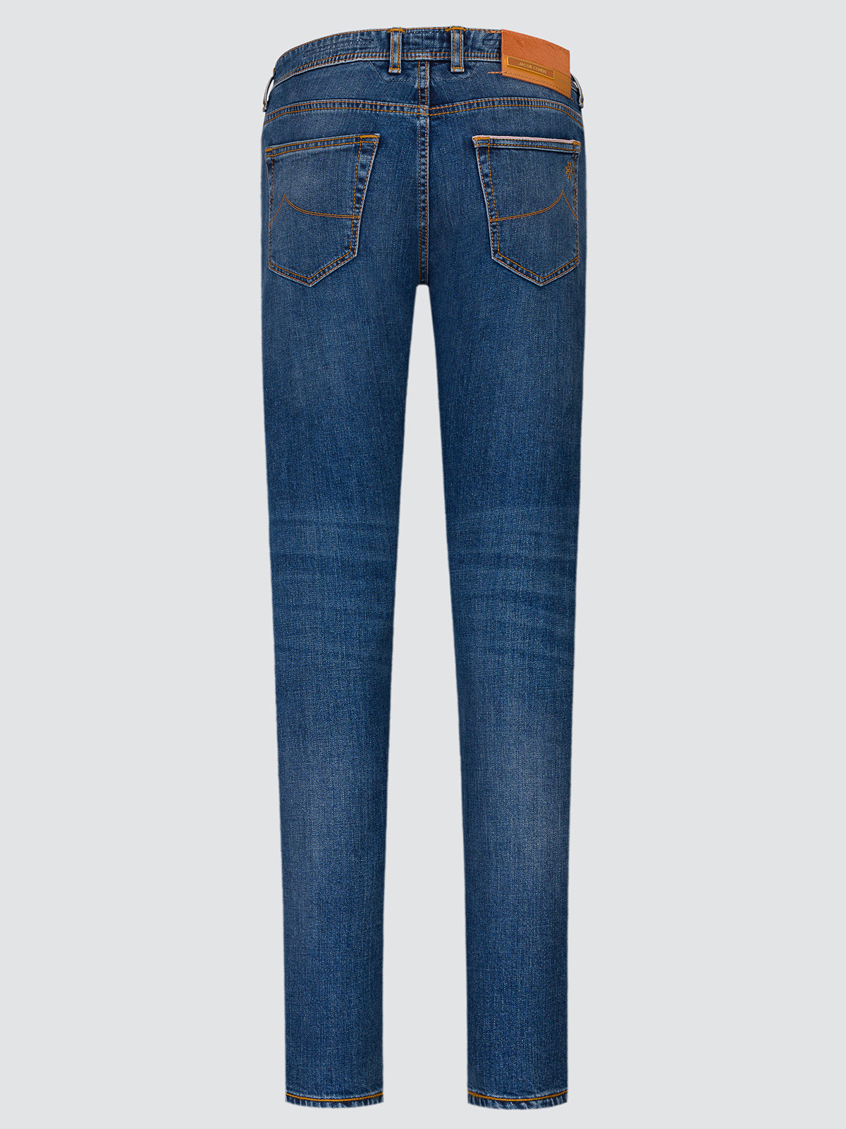 Full-length view of mid blue stretch selvedge jeans laid flat, seen from the back, with the tan leather patch at the waistband.