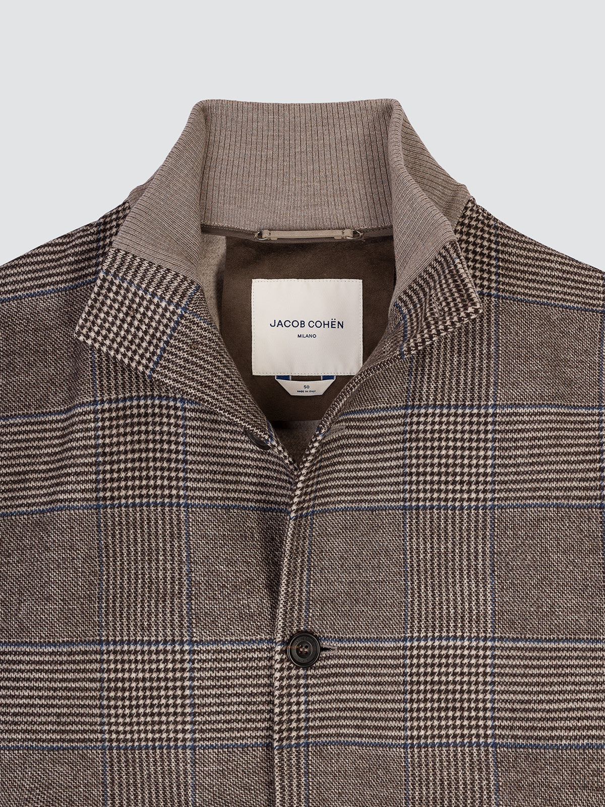 Close-up of the open collar of the Prince of Wales check jacket, showing the ribbed undercollar and the Jacob Cohën interior label.