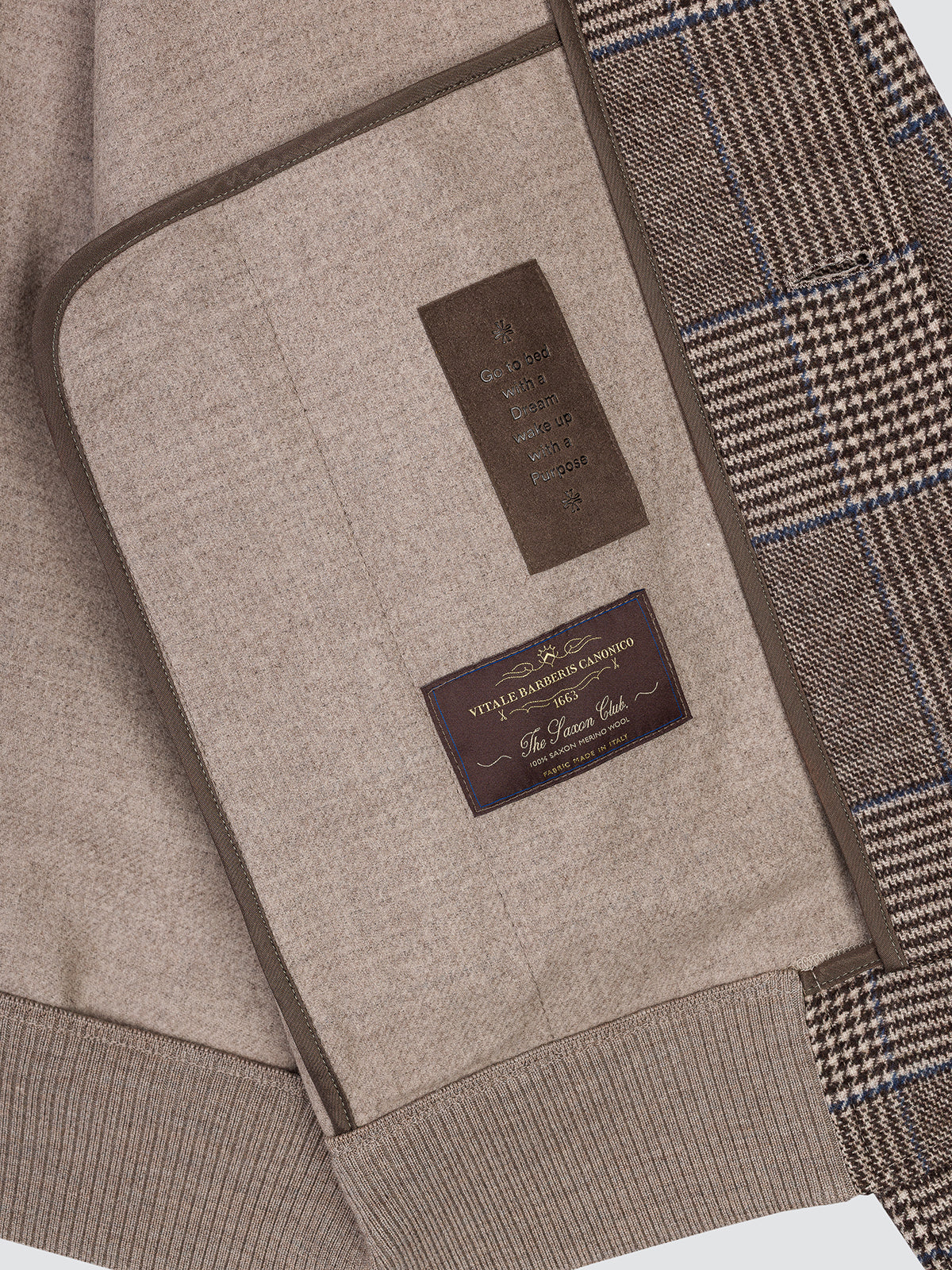 Folded detail of the Prince of Wales check flannel showing the beige ribbed hem and the brand label.