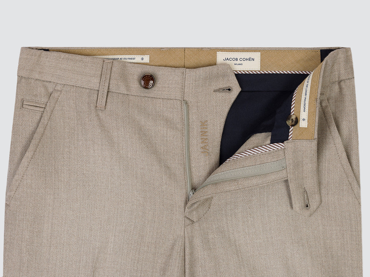 Close-up of a pair of light beige textured trousers by Jacob Cohen, showing the front waistband, button closure, belt loops, and an open right pocket revealing a navy blue inner lining.