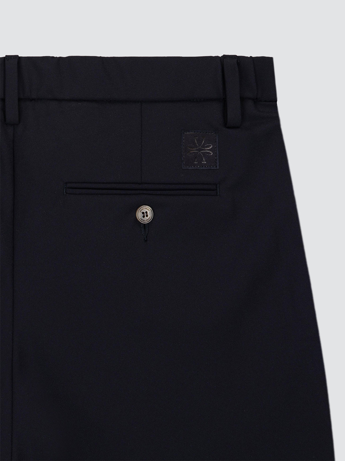Close-up of the back waistband and rear pocket area of black trousers navy blue model Gray from Jacob Cohën, featuring a small square brand patch and a single button closure.