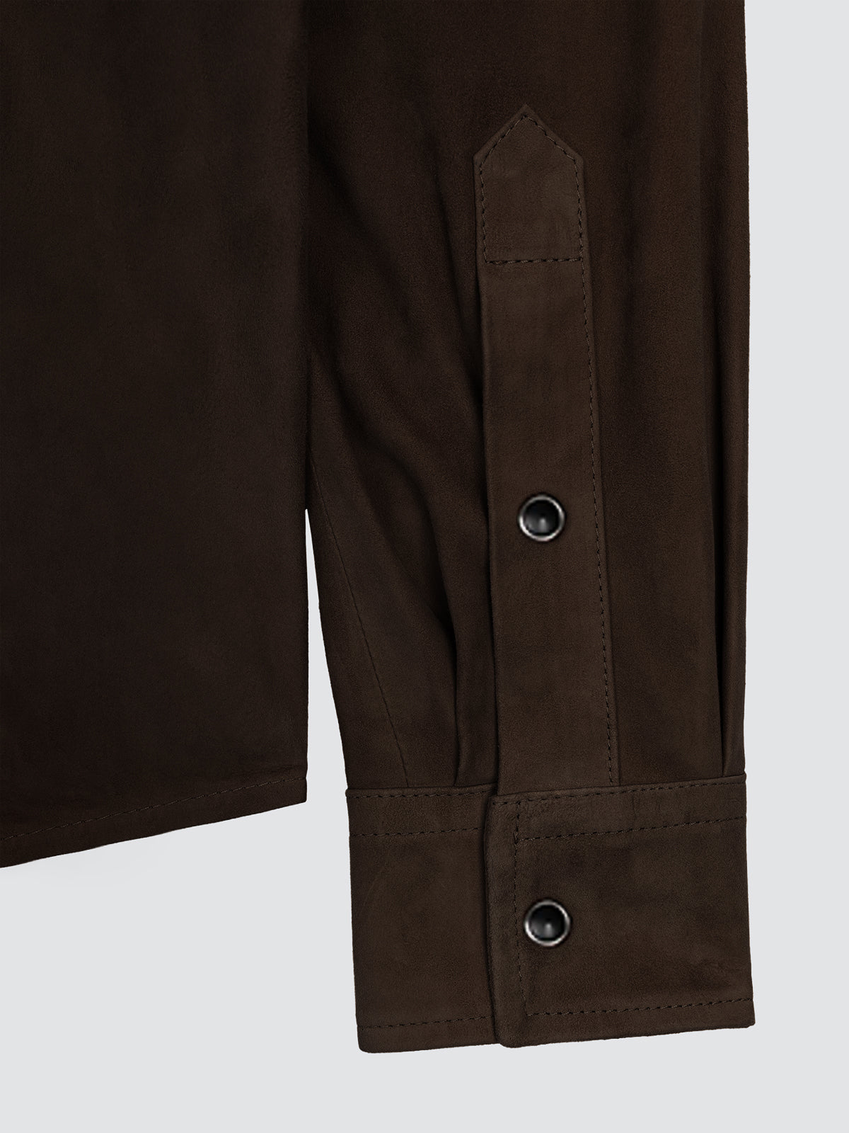 Close-up of the buttoned cuff and placket of the brown suede overshirt