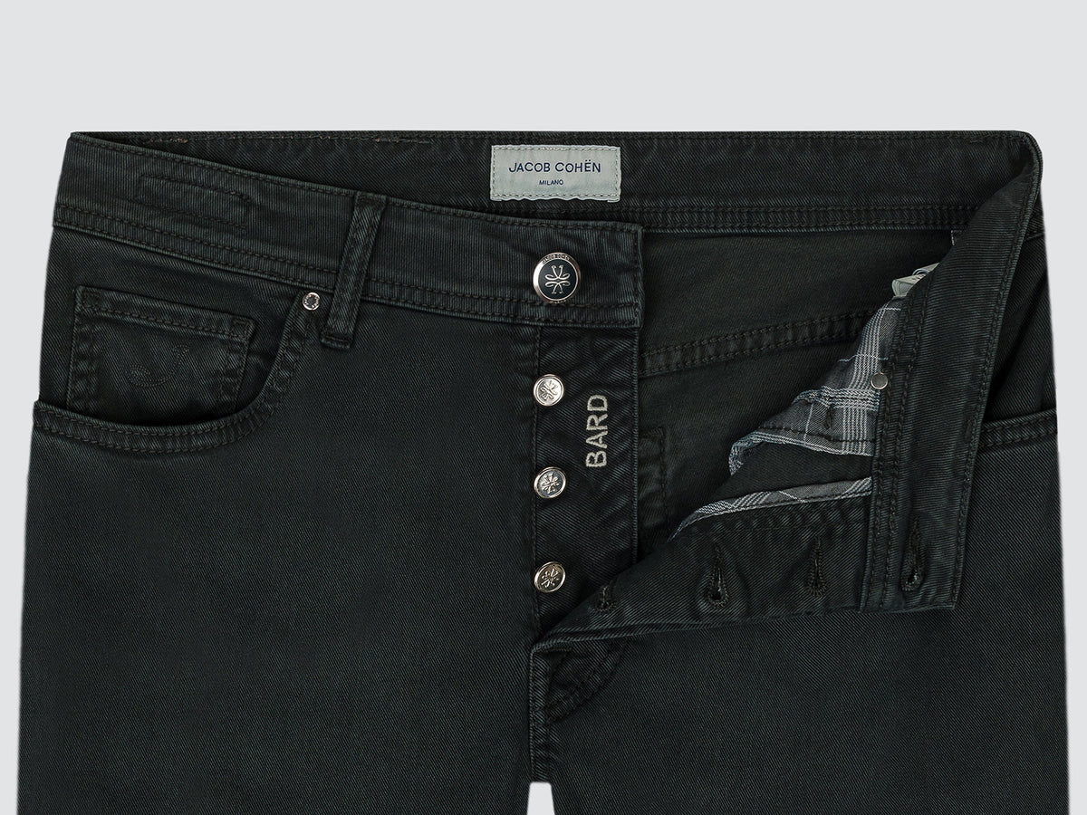 Close-up of the open button fly of the dark forest green Bard trousers, with the Bard-engraved buttons