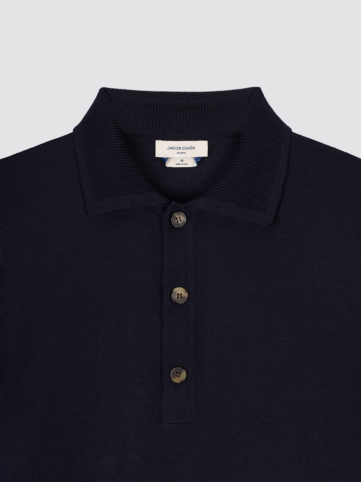 Close-up of the collar and horn buttons of the navy wool and silk polo