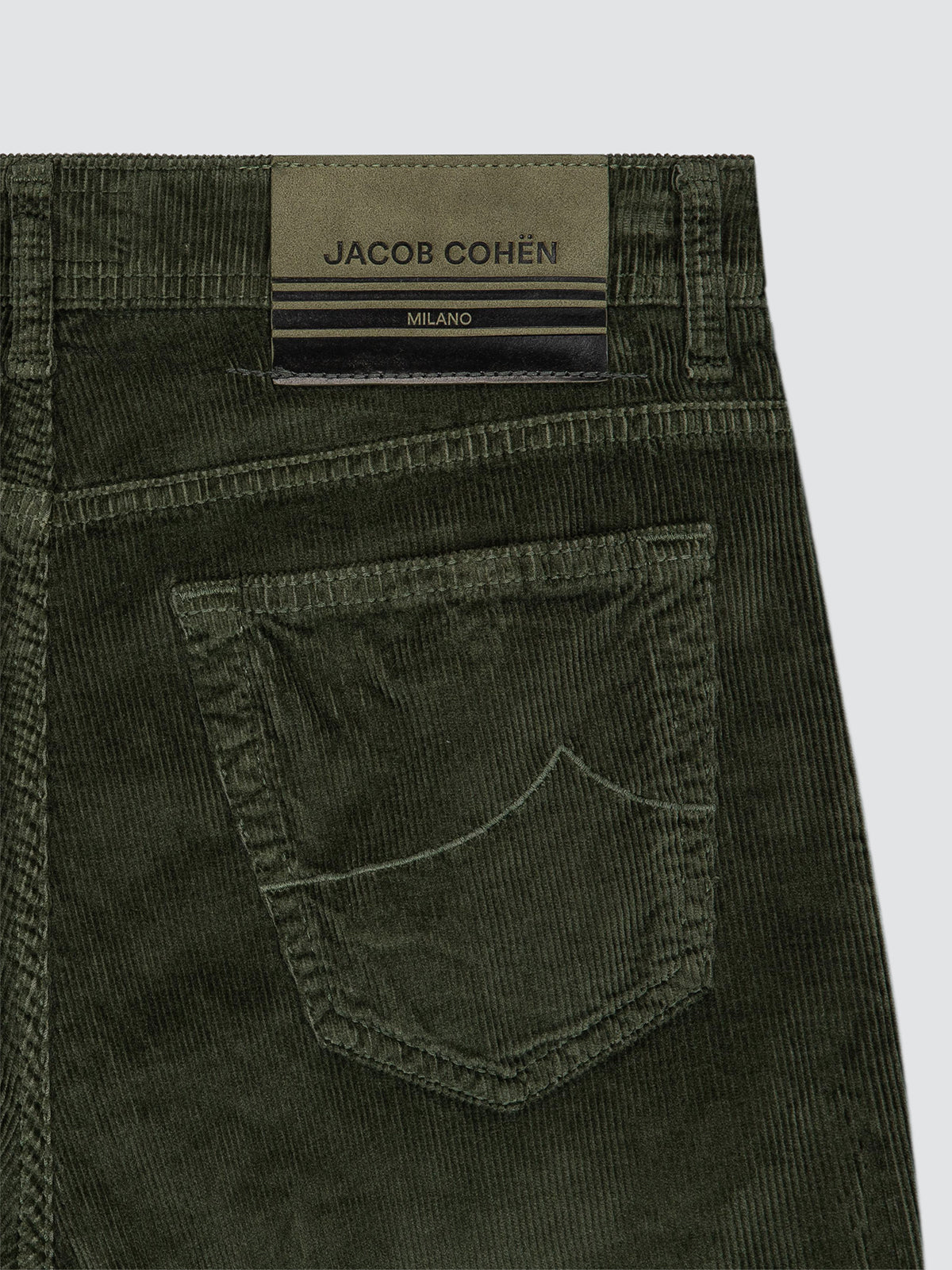 Close-up of the back waistband and pocket area of dark olive corduroy jeans by Jacob Cohen Milano, showing the brand label and fabric texture.