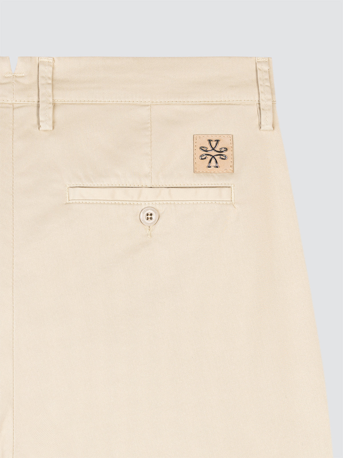 Beige pants with a brand logo on a light gray background