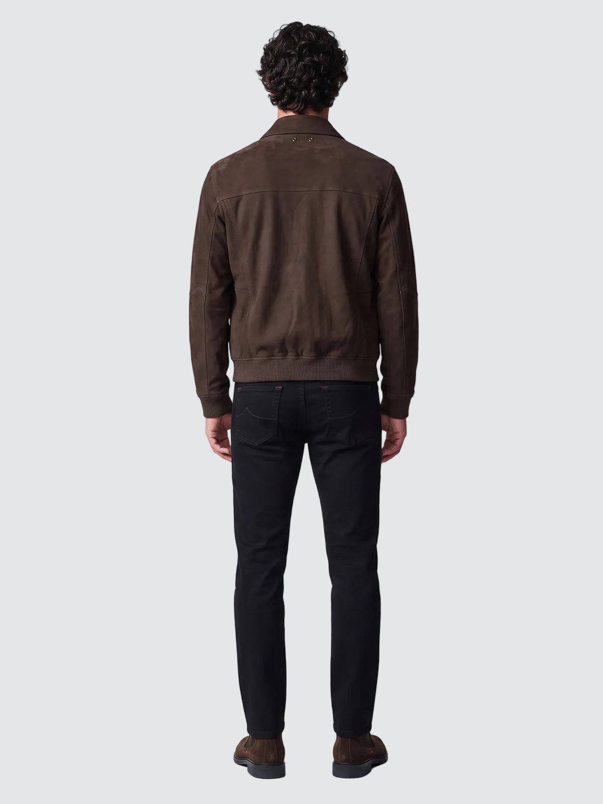 Back view of the dark brown nubuck aviator jacket worn with dark jeans