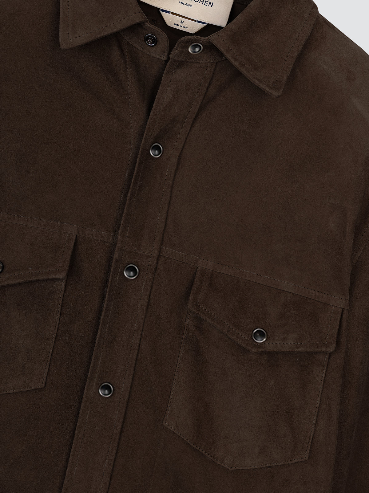 Close-up of the chest flap pockets and resin buttons of the brown suede overshirt