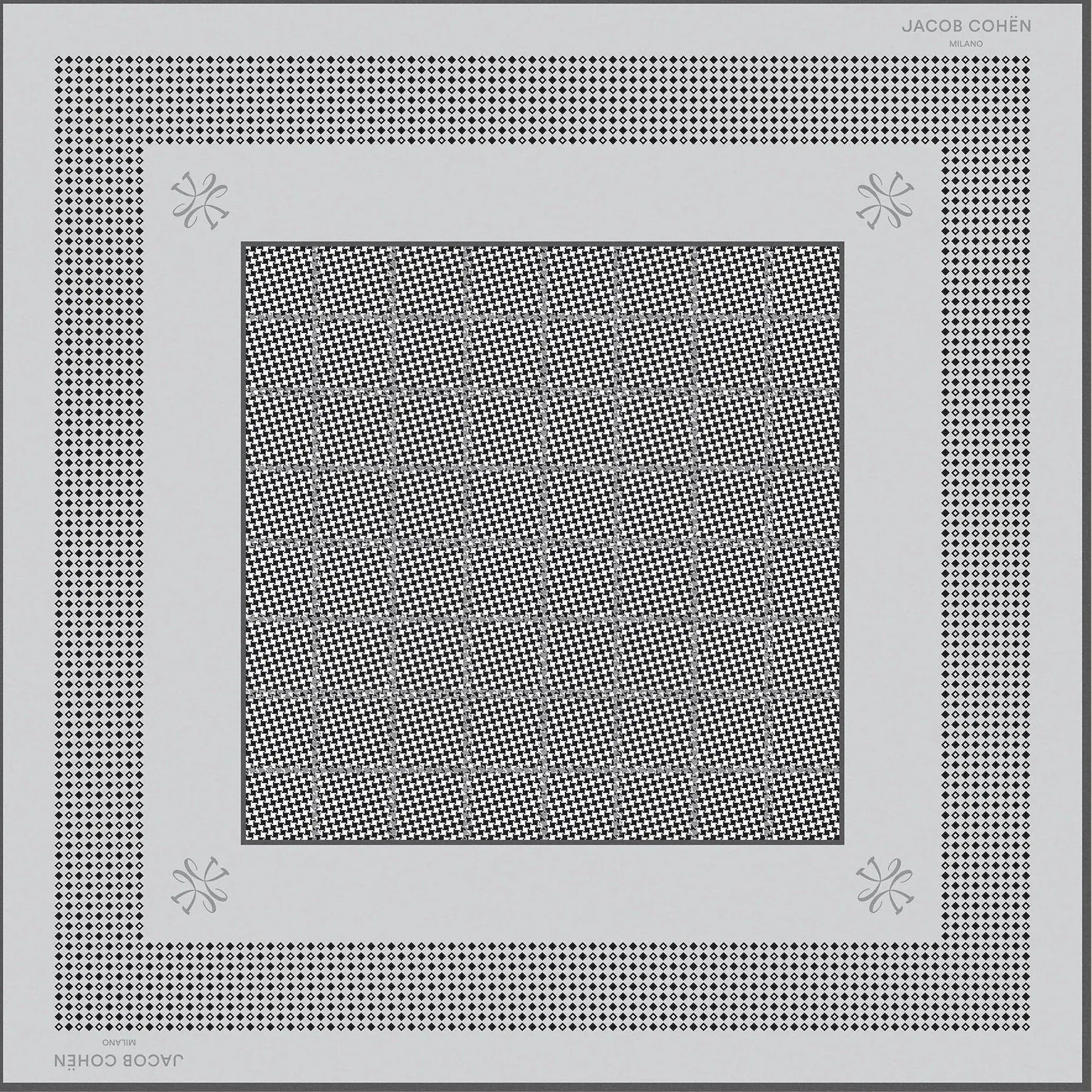 A square scarf with a geometric pattern, featuring a central gray patterned square surrounded by white and black patterned borders, displayed on a light beige background.