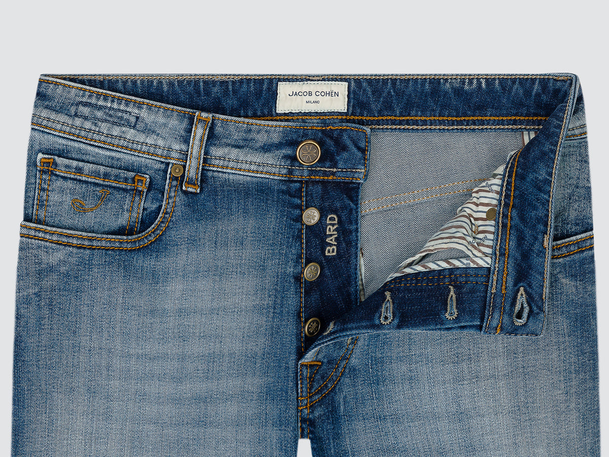 Close-up of the open button fly of the light blue Bard jeans, with the Jacob Cohën waistband label