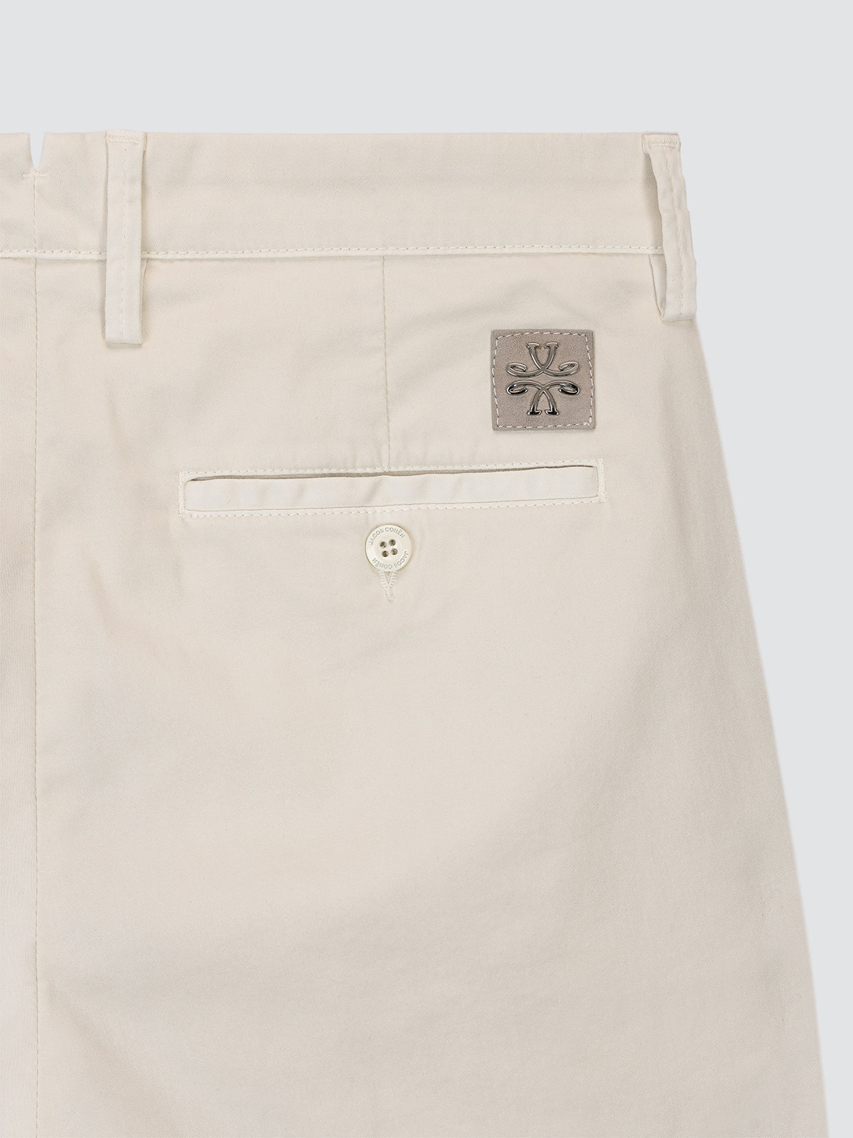 Beige pants with a brand logo on a light gray background
