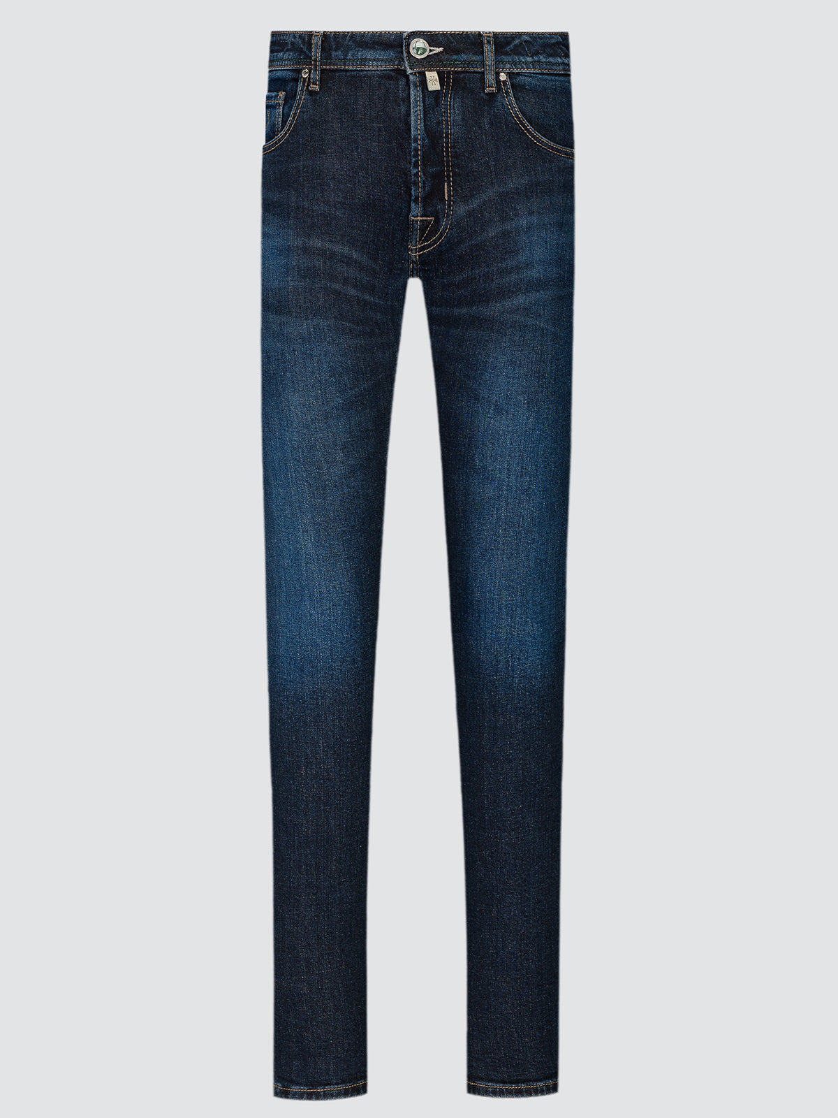 Full-length front view of blue Nick slim jeans laid flat, with a faded wash and a tan leather patch at the back waistband.