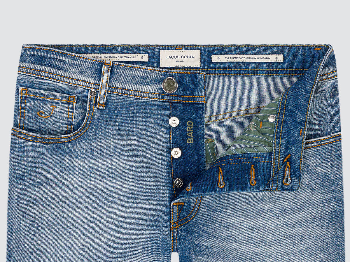 Close-up of the open button fly of the light blue Bard jeans, showing the Bard-engraved buttons