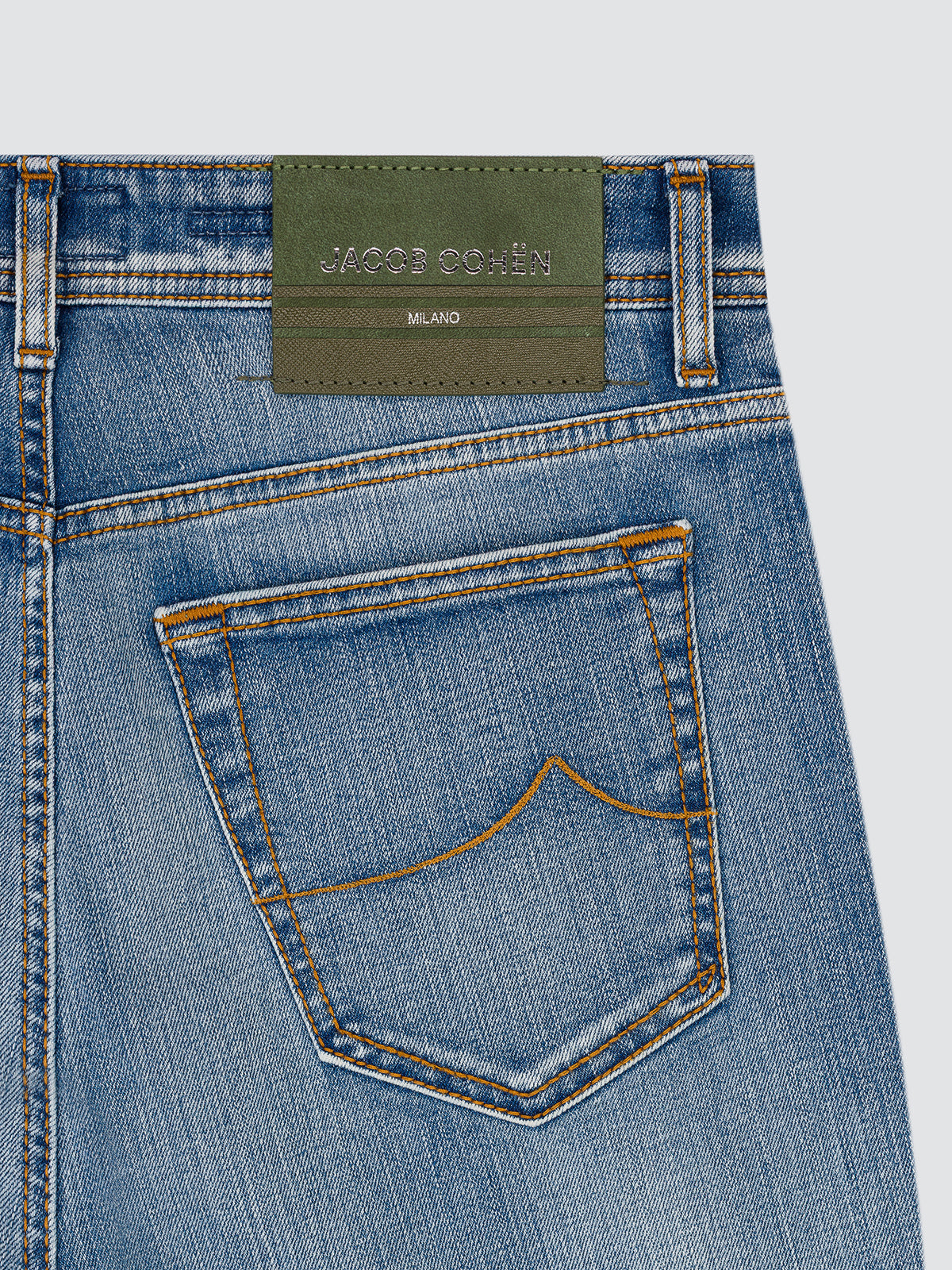 Close-up of the back pocket of the light blue Bard jeans, with the green leather patch and arrow stitching