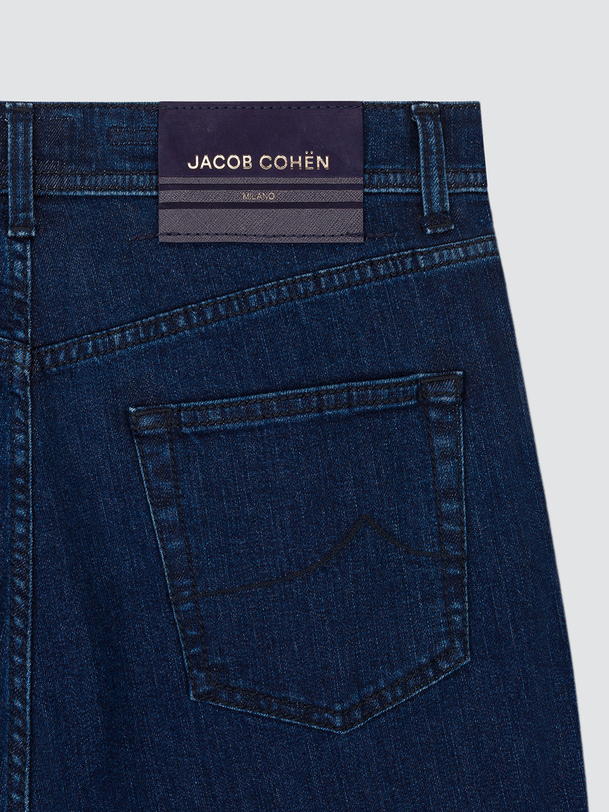 Close-up of the back pocket of the dark blue Edo jeans, with the Jacob Cohën leather patch