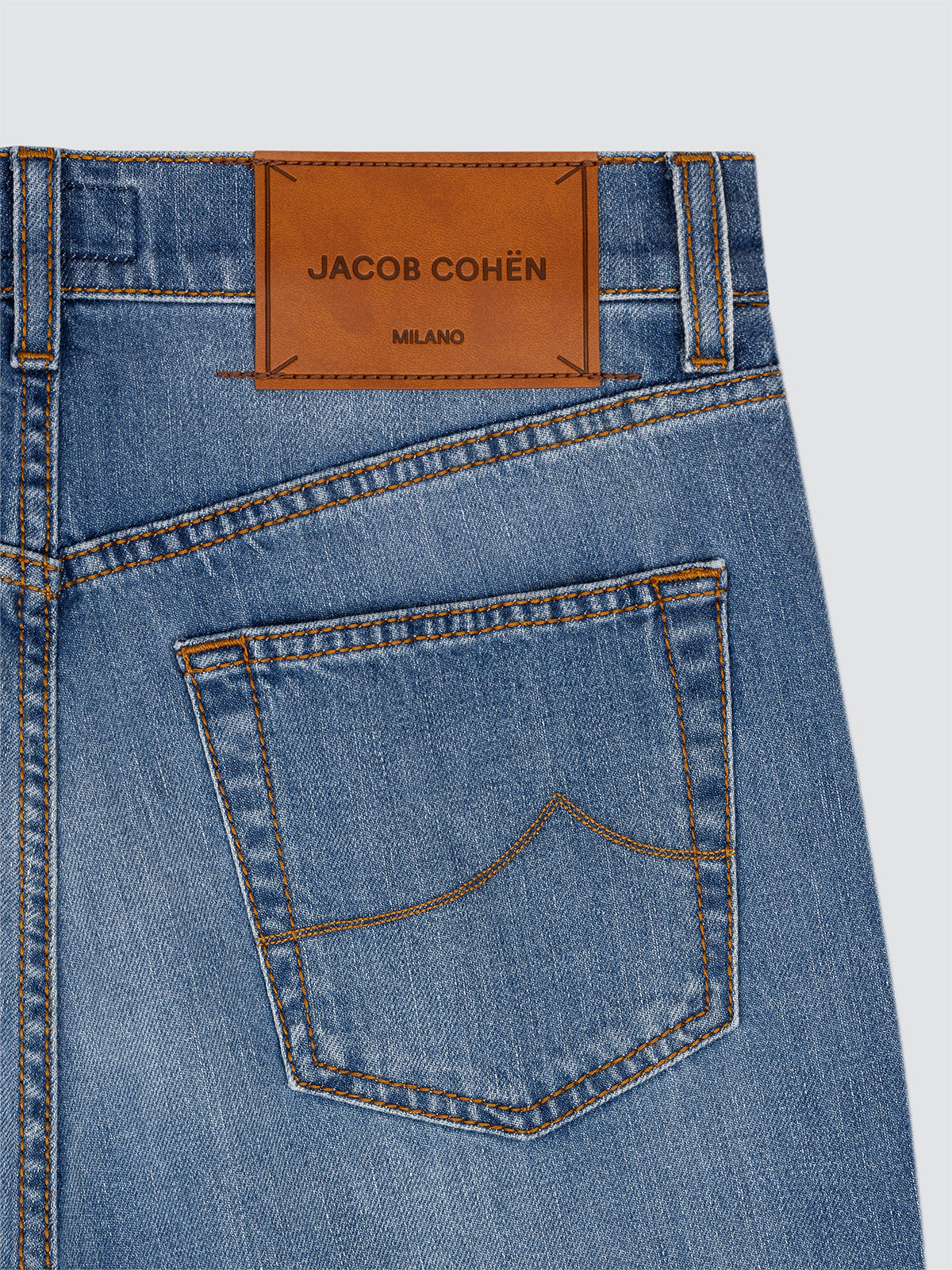 Close-up of blue jeans Edo with a Jacob Cohen label on a light gray background 