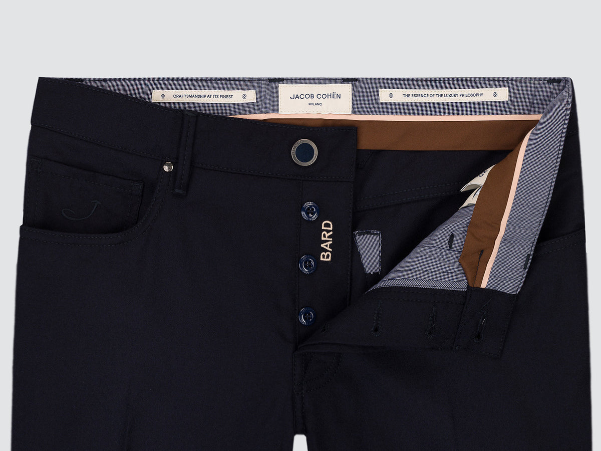 Close-up of the open button fly of the navy flannel Bard trousers, showing the inner labels